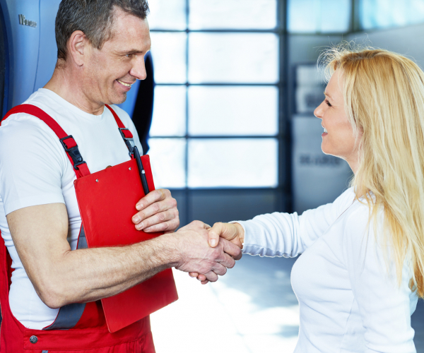 Female customer and mechanic shake hands